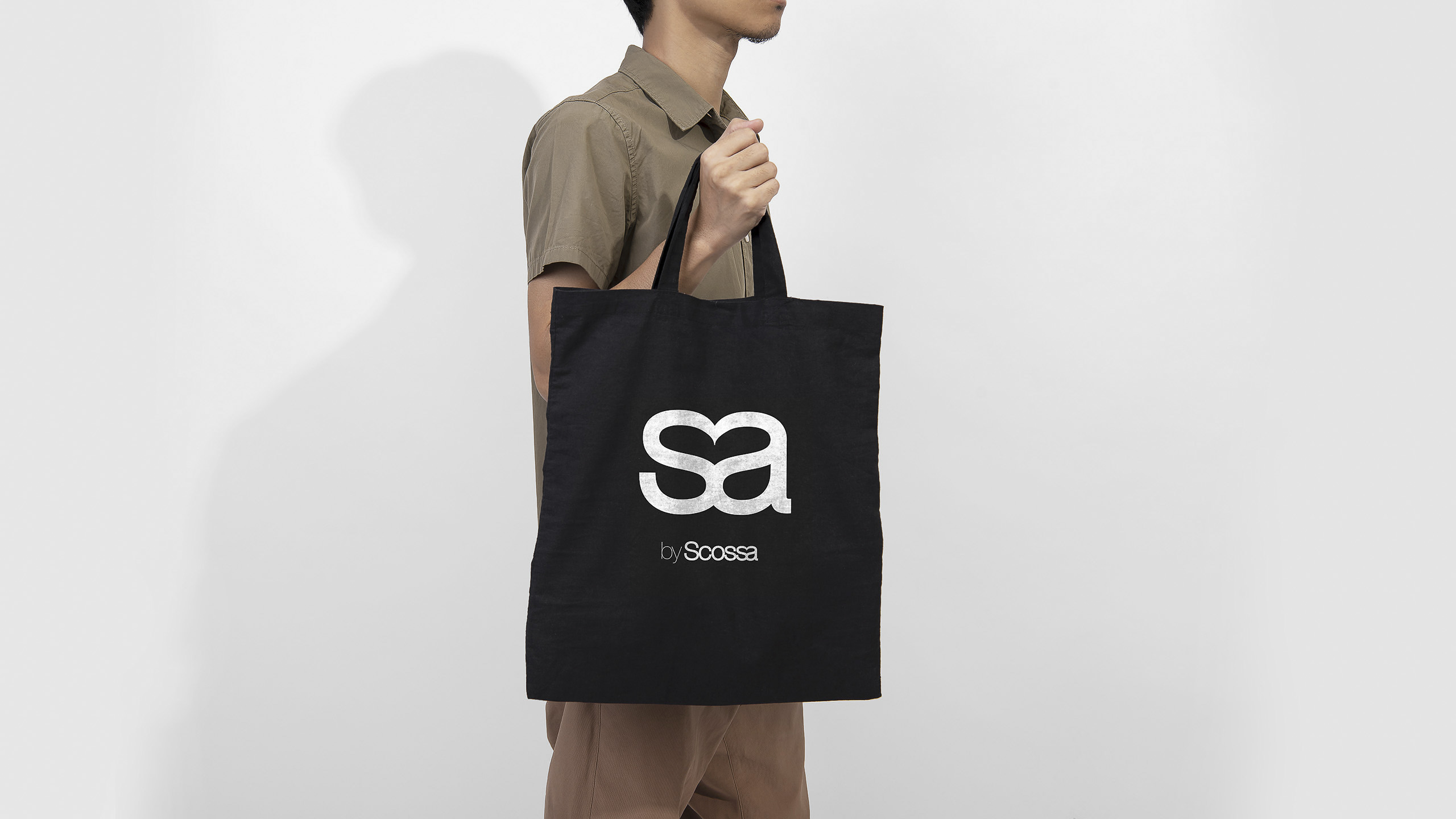 Man is holding black bag canvas fabric for mockup blank template